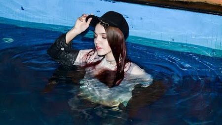 young girl in wet clothes in the pool